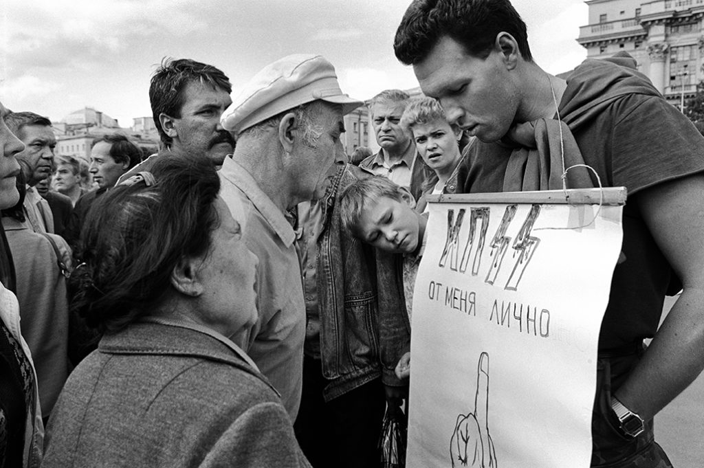 Giovane manifestante regge un cartello di insulti al PCUS. Piazza del Maneggio, Mosca